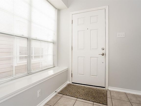 Solid Metal Front Door and Lots of Natural Light at the 2 Story Entryway with Tiled Floors.