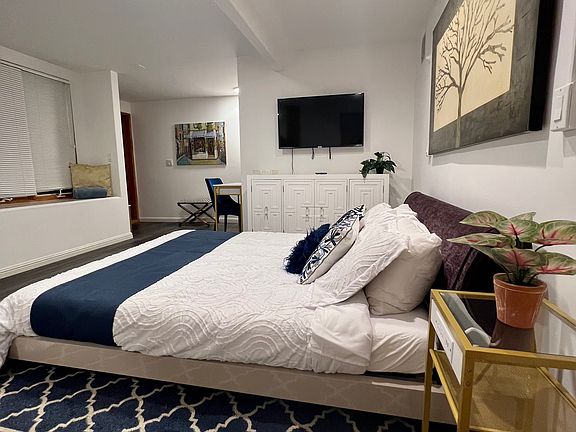 Queen size bed, dresser, and working desk.