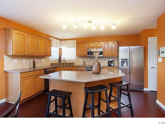 Updated kitchen with stone tile backsplash, quartz countertops, stainless steel appliances.