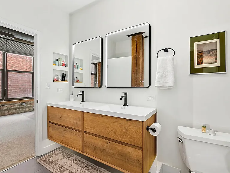 Recently refurbished bathroom with dual sinks and vanity lighting