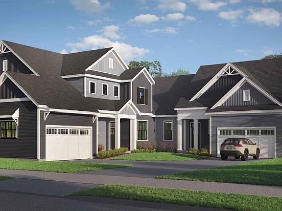 A two-story, dark-colored suburban house with white accents, multiple peaked roofs, and two garages