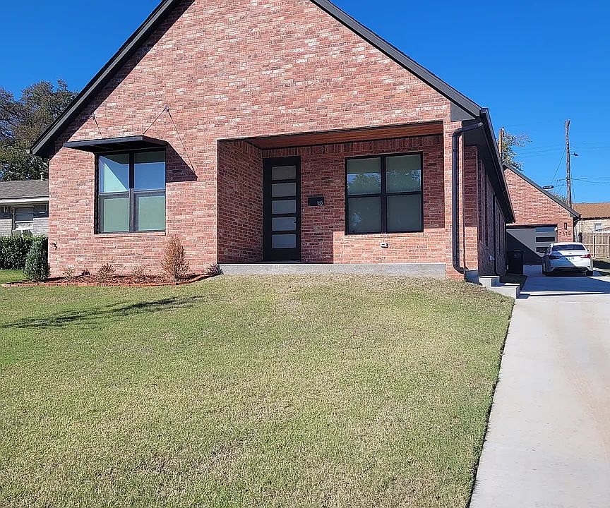 View of front of home featuring a front yard and brick siding. Covered patio.