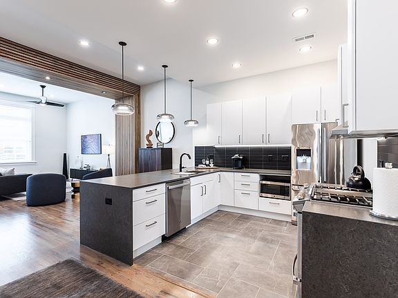 Beautiful waterfall quartz counters and German cabinetry highlight this chefs kitchen. Highend appliances include gas range, garbage disposal, and lots of space. Opens to great room and peninsula fits 5 easily.