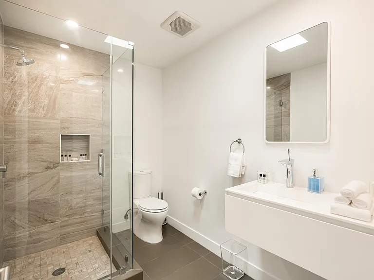 Indulge in luxury in the beautifully appointed bathroom, complete with a shower and all the essential amenities for a comfortable stay.