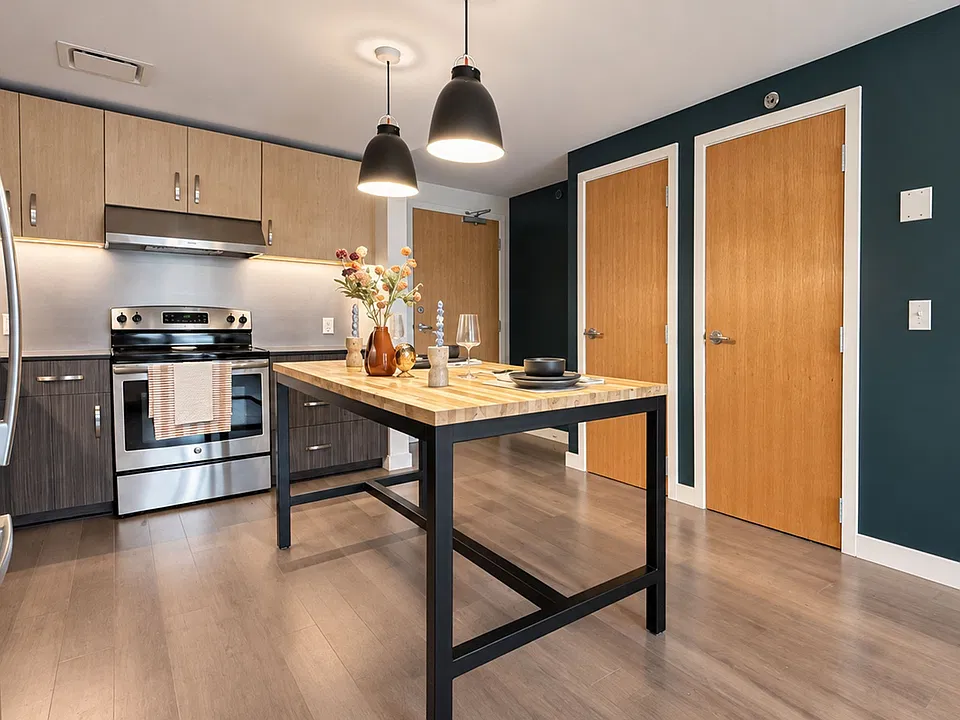 Enjoy an open-concept kitchen with stainless steel appliances, modern cabinetry, and a spacious island with seating at Farmers Park Apartments. See what's waiting for youschedule a tour today!