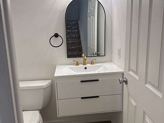 Powder 1/2 bath downstairs with designer vanity and light.