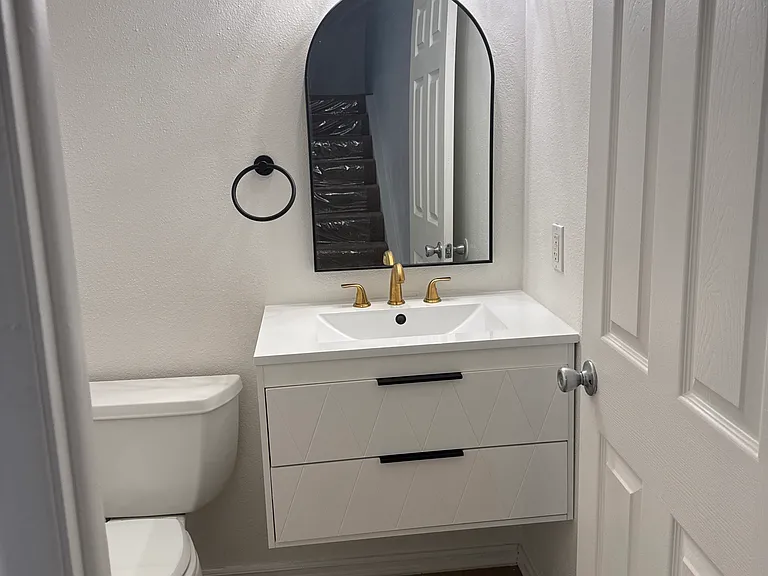 Powder 1/2 bath downstairs with designer vanity and light.