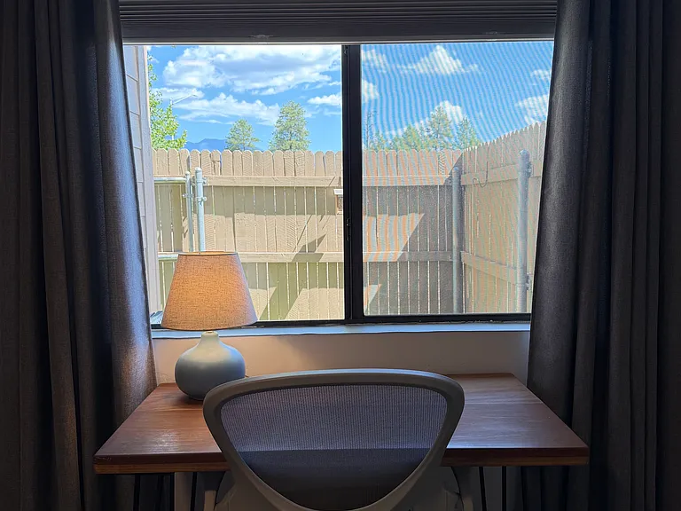 2nd bedroom with desk and chair, view to back patio.