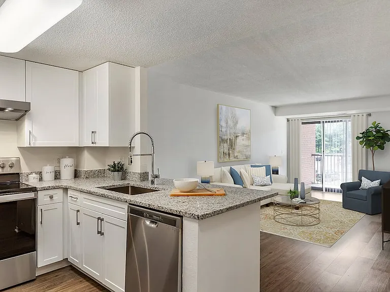 Renovated Package III kitchen and living area with white cabinetry, grey granite countertops, stainless steel appliances, and hard surface flooring