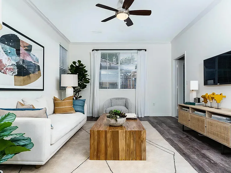 Stylish Apartment Living Area Featuring Ceiling Fan and Wall Art
