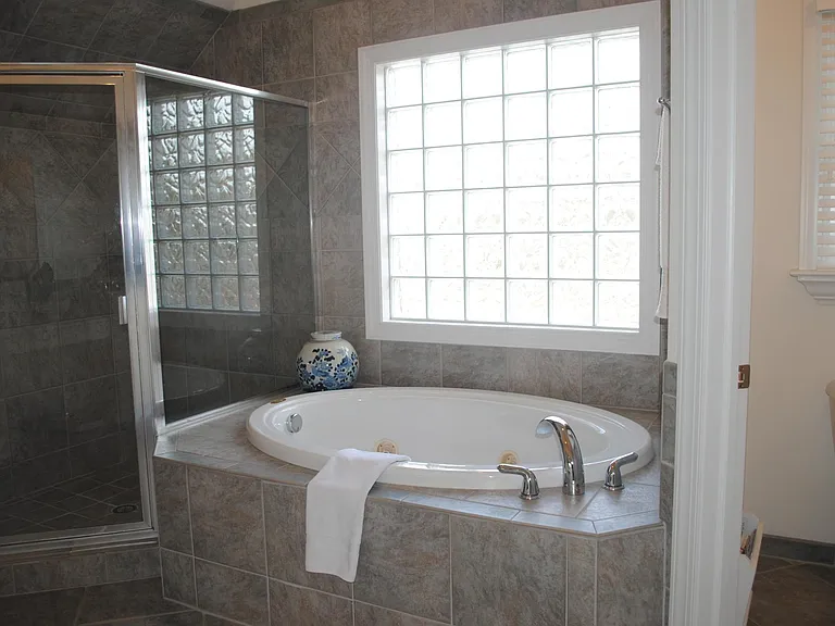Master bath with private commode, jetted tub, and walk-in shower
