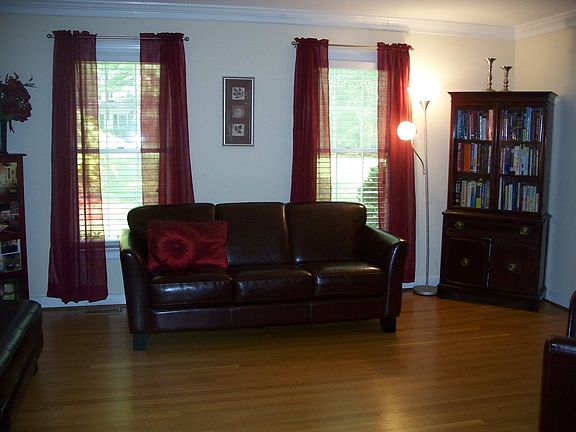 Living room with hardwood floors & crown molding.
