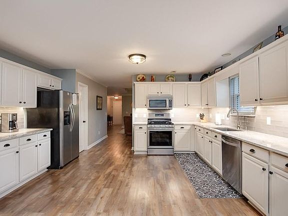 Spacious kitchen upgraded for a chef with stainless appliances, granite counters and gas stove.