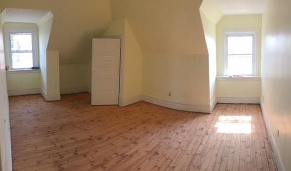 Large spacious bedroom with natural sunlight and multiple al