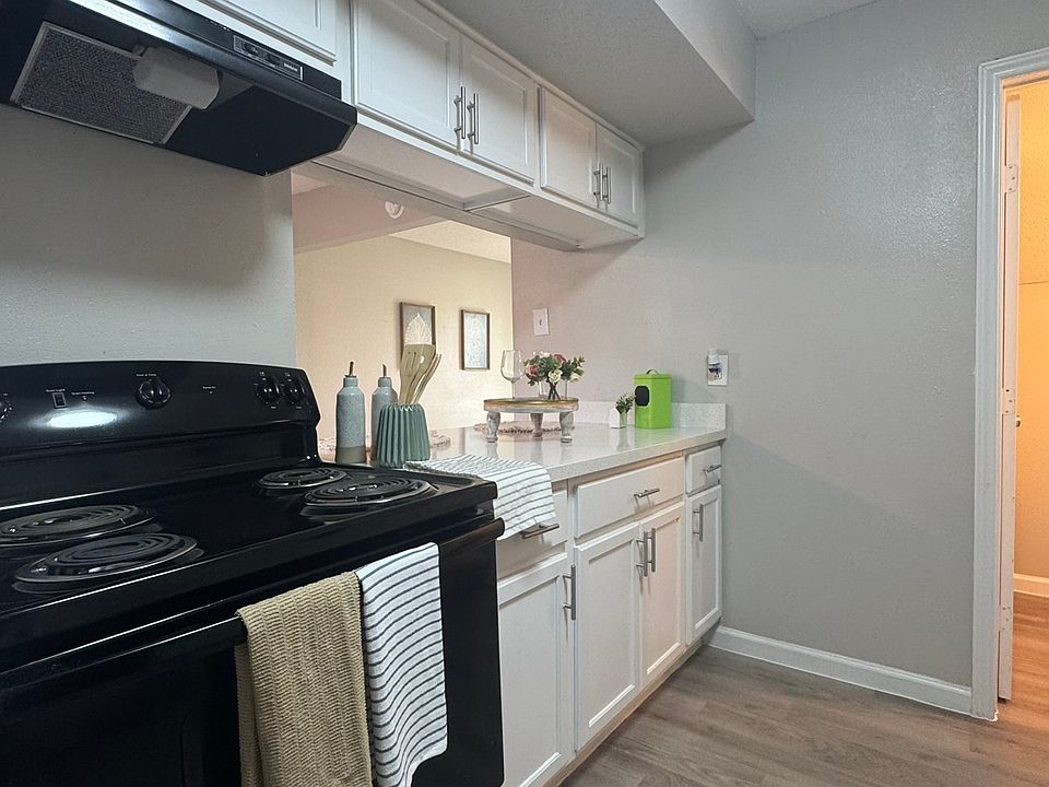 This modern kitchen features crisp white cabinetry, sleek countertops, and a clean, open layout accented by updated appliances.