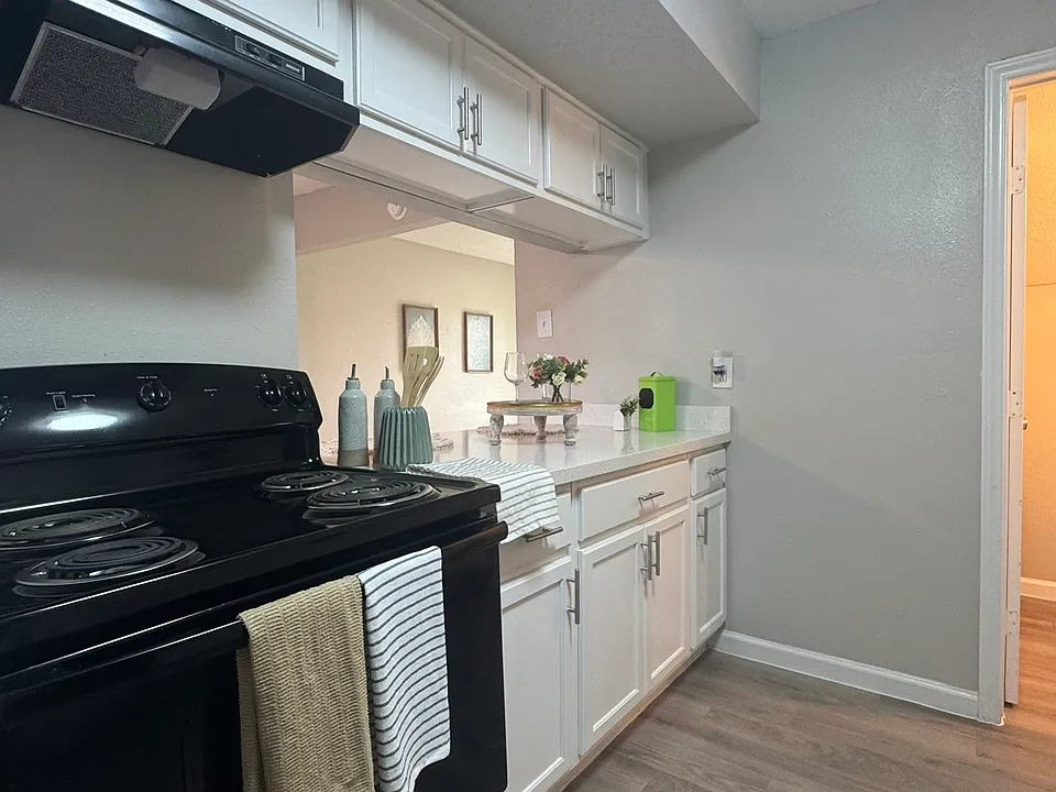 This modern kitchen features crisp white cabinetry, sleek countertops, and a clean, open layout accented by updated appliances.