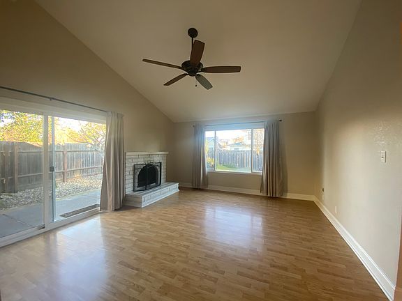 The Living Room features plenty of light, vaulted ceilings and a wood burning fireplace