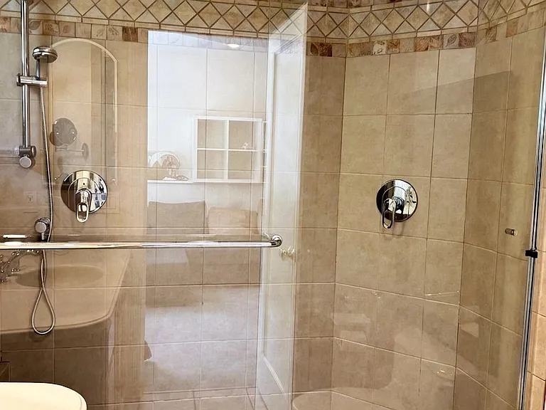 Garden level full bathroom with double headed shower and designer tiles made by an artist.