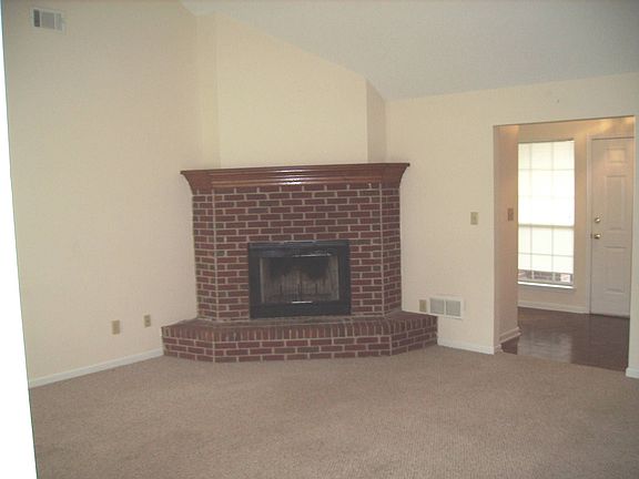 Family Room w/ Corner Fireplace & Vaulted Ceiling