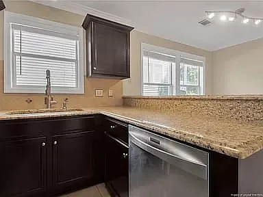 Kitchen with granite countertops, SS appliances with modern lighting throughout and tile flooring.