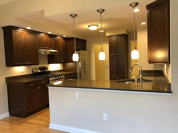 Spacious kitchen with granite countertops, deep sink, and pull down faucet