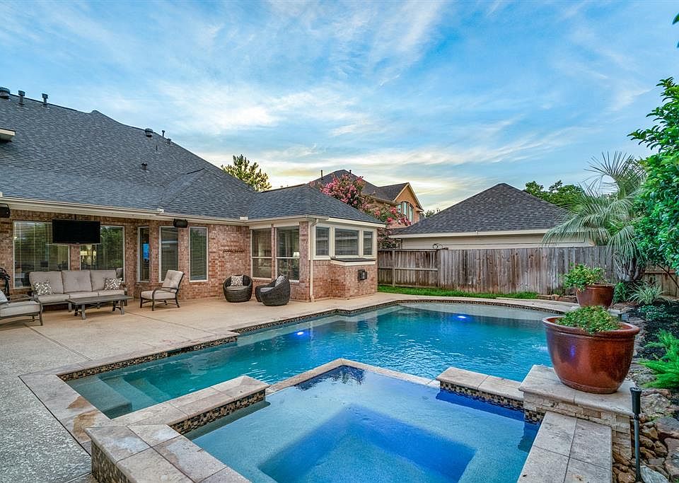 A backyard paradise with covered patio, pool with spa and fountains awaits in Gleannloch Farms.