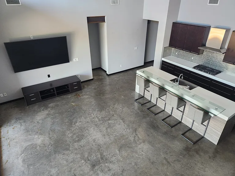 Living Room and Kitchen View from Stairway to Loft. 86" Television will remain in home for Tenants to Enjoy.