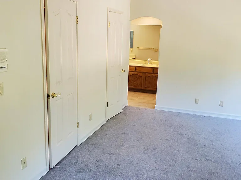 primary bedroom view of wall with dual closet entry
