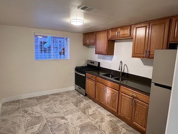Completely remodeled kitchen. New cabinets, new stove and refrigerator, new counter-top and tile flooring.