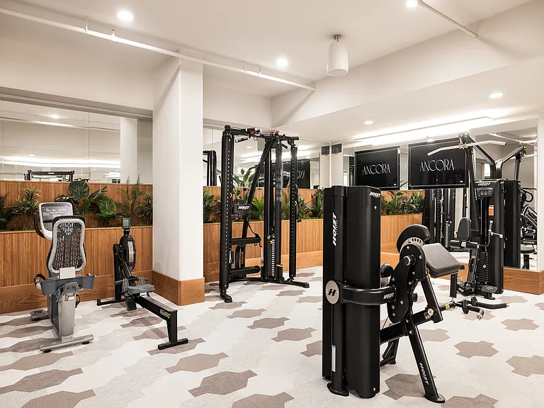 Modern fitness center with state-of-the-art exercise equipment, sleek design, and mirrored walls for a dynamic workout environment.