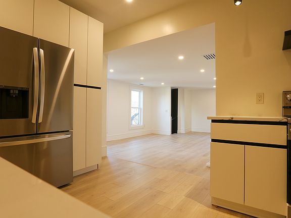 Kitchen opens to spacious living room area with private back staircase.
