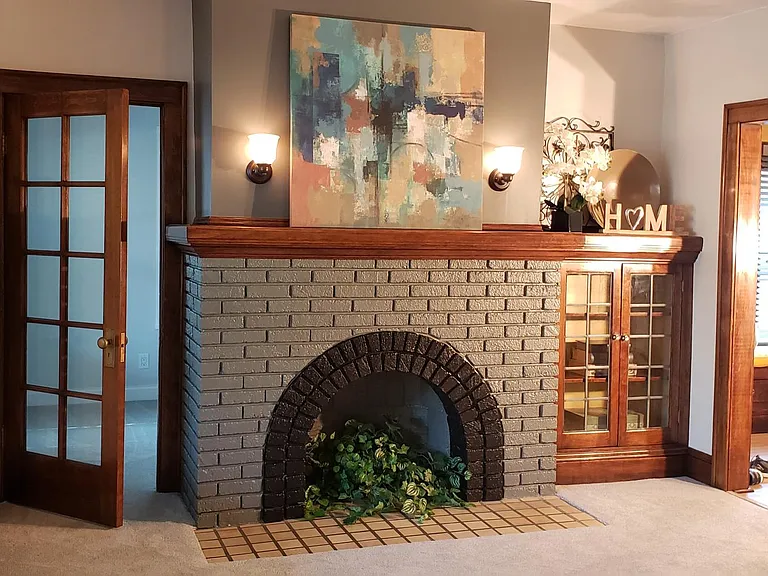 Living room fireplace with display area. The open door on left enters into the secret room. Your home office or whatever you wish it to be!