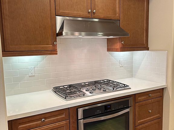 Chef's Kitchen with stainless oven, gas stove, and hood