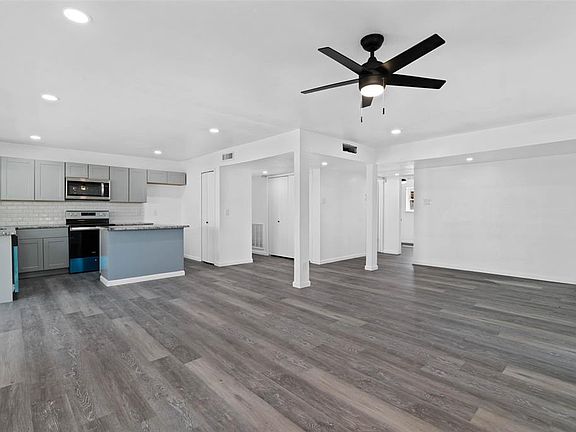 Kitchen featuring ceiling fan, stainless steel appliances, sink, dark hardwood / wood-style floors, and gray cabinetry