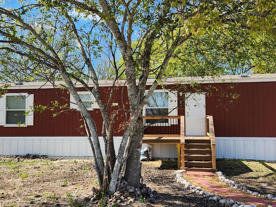 Front photo of home. Parking pad for two cars is located at end of the visible walkway.