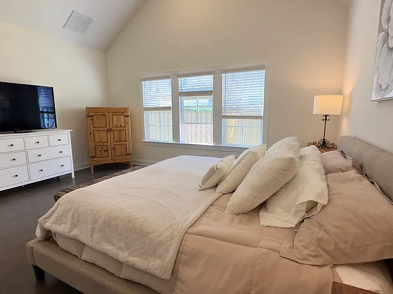 Primary bedroom with dresser and television