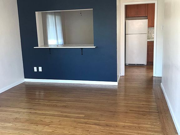 Living room with kitchen and dining room in background