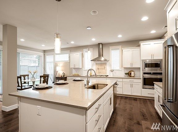Another view of the kitchen: Signature Look of Village Life kitchen with upgraded White cabinets (Canyon Creek), Pental Quartz slab counter tops, full height subway tile backsplash, Pot-filler faucet above the 5 burner gas cook top is accented with upgraded tile backsplash under the vent hood. To the left is the butler's pantry and enormous walk-in pantry. S/S fridge is an included upgrade feature. Lot 1 is complete and Move-in Ready!