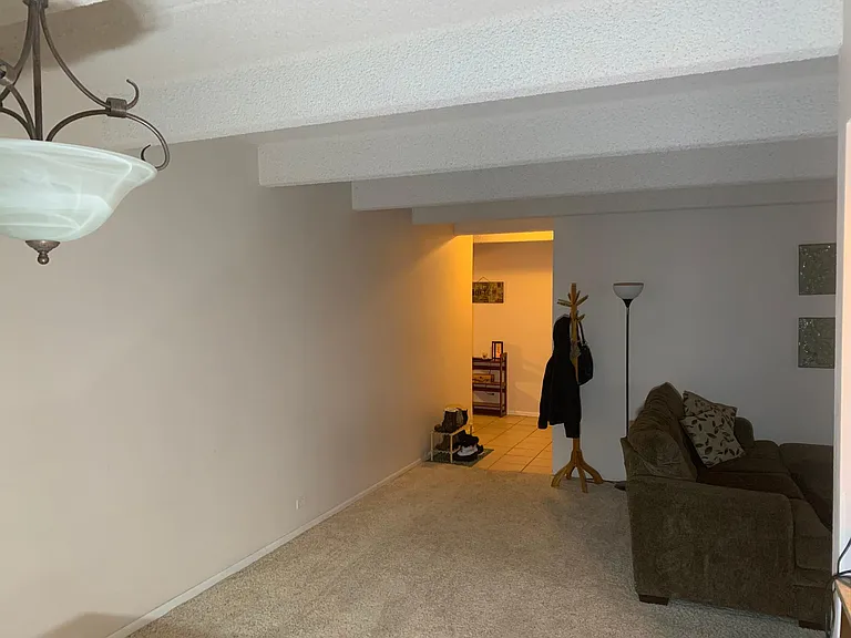 Looking from the dining area into the entryway towards the bedrooms and bathrooms.