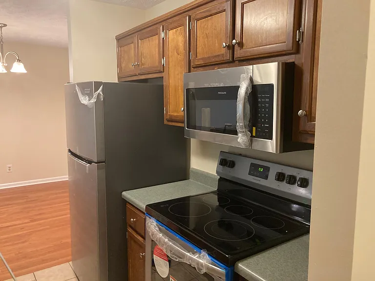The kitchen features new fixtures and appliances: microwave, ceramic stovetop / range, dishwasher, and refrigerator with ice maker.