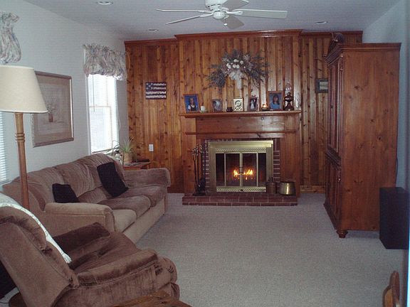 Living room has  custom woodwork, wood-burning FP, ceil fan, recessed lighting