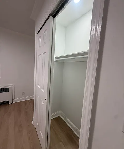 Spacious bedroom closet with built-in shelving & recessed lighting
