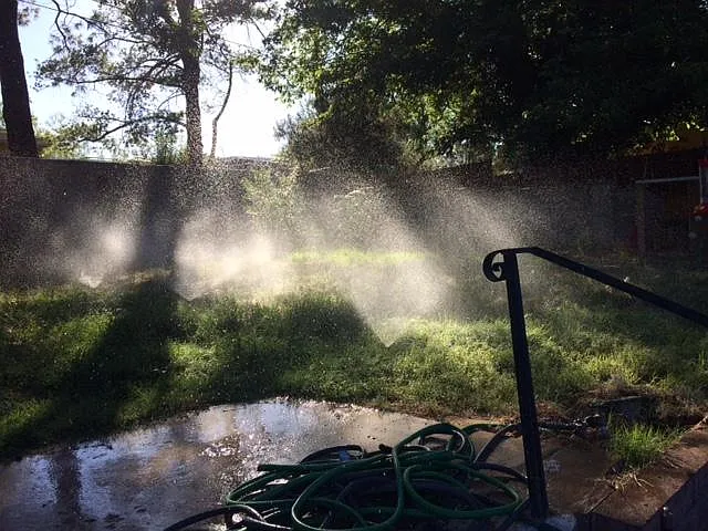 Backyard with sprinklers on