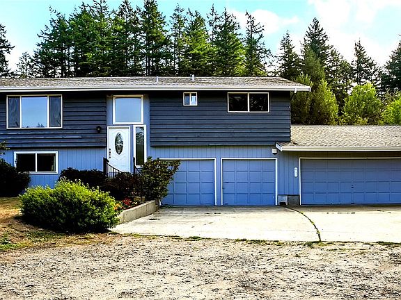 This large, split-level home on over 3 acres has two attached garages and two detached garages - enough covered parking for 6 vehicles.