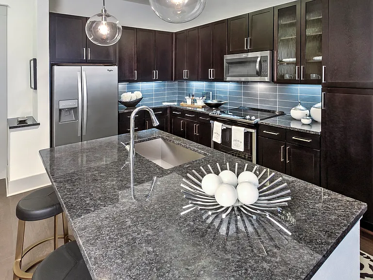 Stunning kitchens feature quartz countertops and custom-patterned tile backsplash.