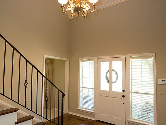 Soaring 2 Story Entry with gleaming hardwood floors and iron stair rail.