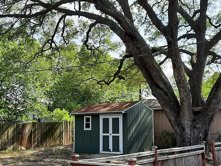 Terrific back yard with shed and deck among a gorgeous tree.