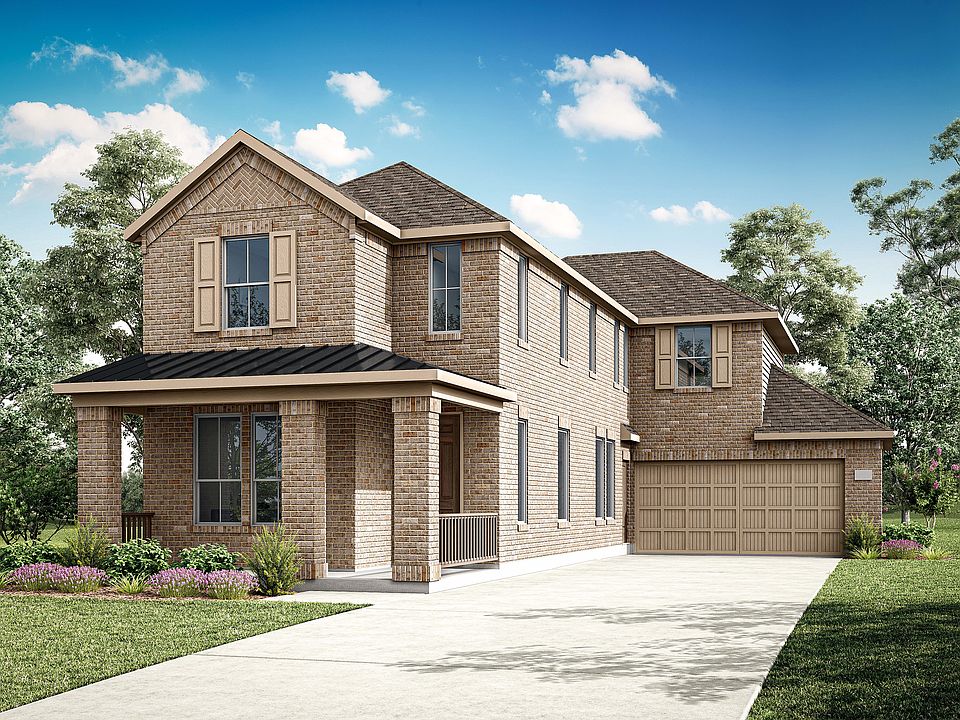 A two-story brick house with a garage, surrounded by lush greenery and a clear blue sky with fluffy