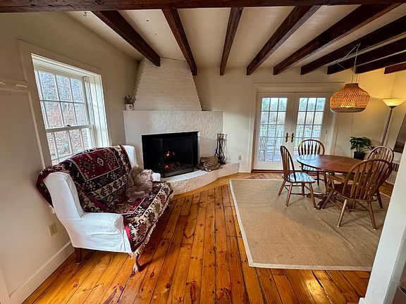 Dining area with working fireplace and beautiful reclaimed pine floors.
