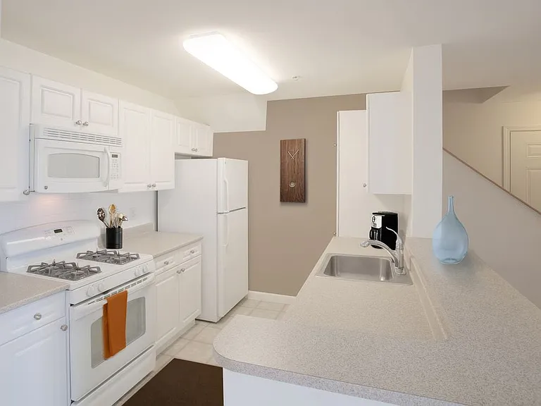Phase I Classic Package I apartment kitchen with white cabinetry and white appliances